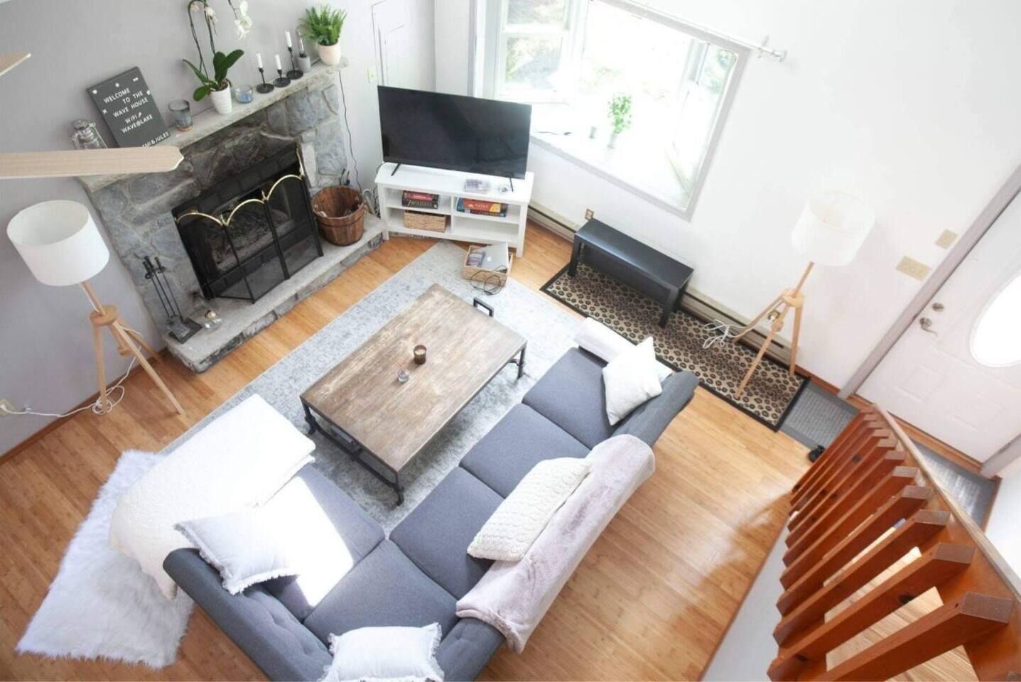A modern living room with a fireplace, a sofa, a coffee table, and a TV.