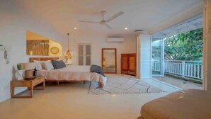 A bedroom with a bed, bedside table, lamp, and a view of greenery outside. - Tropical beachfront villa in Umdloti - Endless summers (eMdloti)