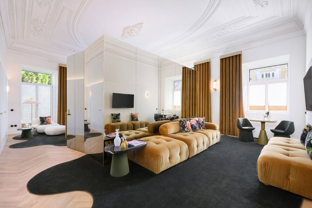 Un salon moderne doté d’un grand canapé d’angle, d’un téléviseur à écran plat et d’une cloison en verre.