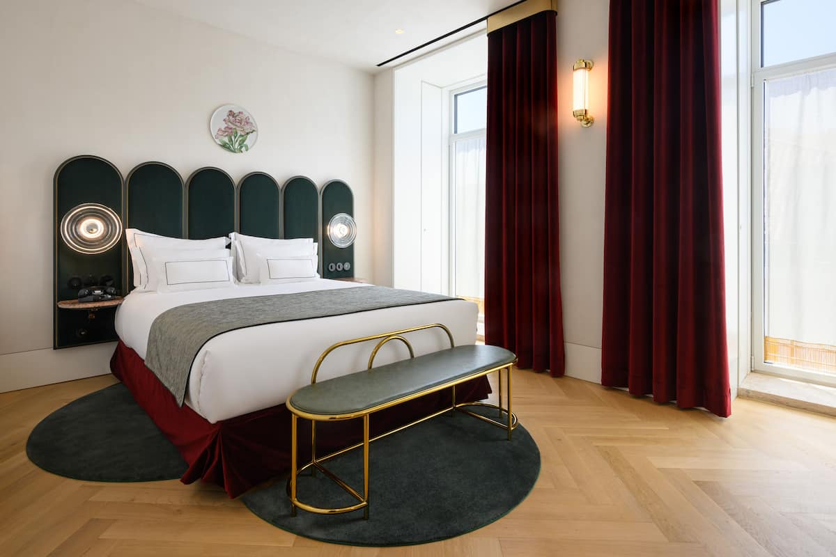 Une chambre à coucher moderne avec un lit, un banc et des appliques murales décoratives.