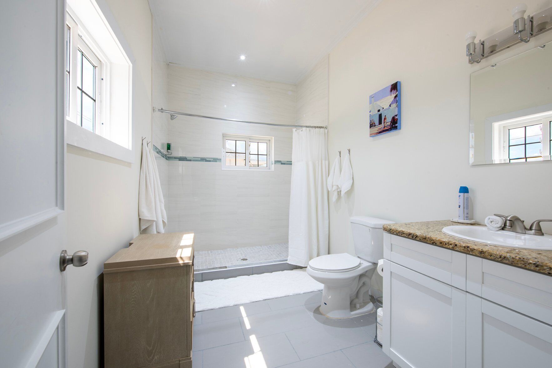 A modern bathroom with a shower, toilet, and vanity.