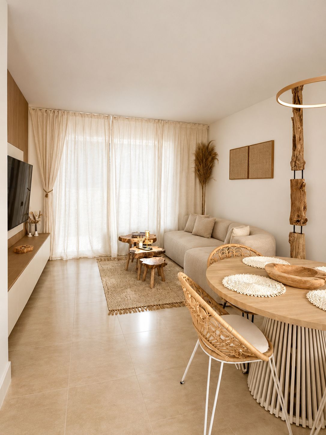 Una sala moderna con un sofá, una mesa de comedor con sillas y un televisor.