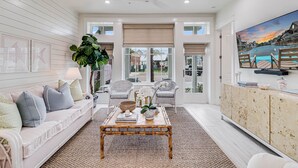 A spacious living room with a large window, a ceiling fan, and a view of the outside.