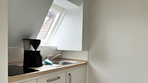 A kitchen with a window, a coffee maker, and a sink. - Haus Möwe App Austernfischer Westerland (Westerland)