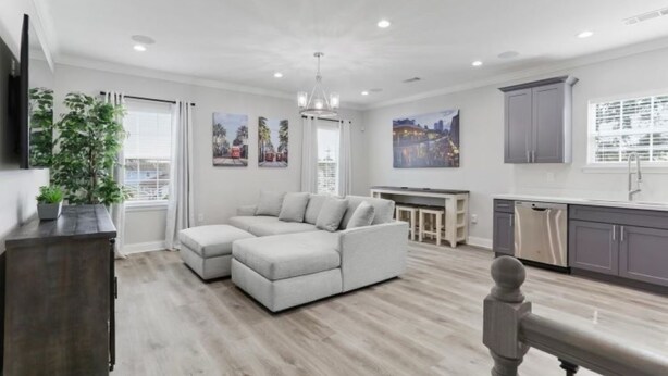 A modern living room with a sectional sofa, a dining area, and a kitchen with grey cabinets. - Pleasant Peachy Escape (New Orleans)
