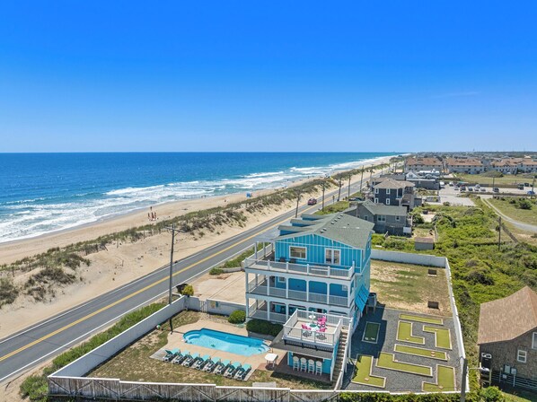 A coastal hotel with a pool, beach view, and a maze garden.