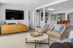 A modern living room with a TV, sofa, and coffee table.
