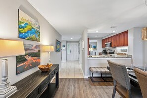 A modern kitchen with wooden cabinets, a central island, and a dining area with a bench and table.
