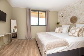 Relax in this serene bedroom with a large bed, flat-screen TV, and a side table.