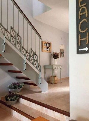 Stunning staircase with a geometric railing and wooden steps, leading to an upper level with a minimalist aesthetic.