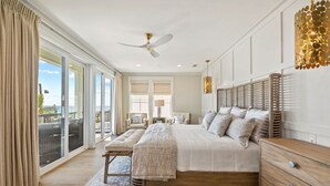 A spacious bedroom with a large bed, a wooden dresser, and a view of the outdoors through large sliding doors. - Emerald View|Easy Beach Access|Unobstructed Gulf Views|Private Pool (Inlet Beach)