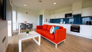 A modern kitchen with white cabinets, a microwave, and an oven. - University of Galway Rooms (Galway)