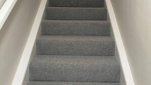 A staircase with carpeted steps and white railings, leading to a room with a white dresser and a coat rack. - Cosy Cottage Apartment (Argyll and Bute Council)