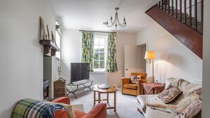 A living room with a sofa, armchair, TV, and a lamp. - Prince's Cottage (Thornhill)