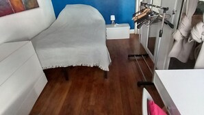Habitación de hotel con cama, una mesita, una silla, un espejo y un soporte para bicicletas.