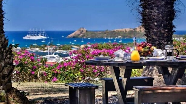 Une table dressée à l’extérieur, avec vue sur la mer et les bateaux.