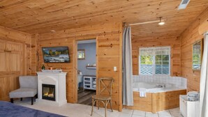 A cozy cabin with a fireplace, a television, a bathroom with a bathtub, and a dining area. - River Road Lodge 7 Bedroom Lodge by NW Comfy Cabins by RedAwning (Leavenworth)