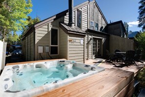 A wooden cabin with a hot tub and outdoor seating area. - Red Feather Chateau: Close To Town/Slopes & Dog Friendly (Breckenridge)