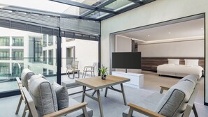 A modern hotel room with a large bed, a TV, and a seating area with a table and chairs. - INVENTIST Hotel Sports Academy (Çekmeköy)