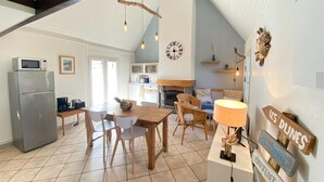 Une cuisine spacieuse avec un coin repas, une cheminée et une horloge au mur.