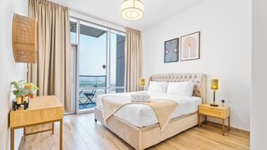 Una camera da letto con un letto, comodini, una lampada, una pianta in vaso e vista sull'esterno.