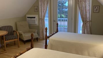 A bedroom with two beds, a ceiling fan, a chair, an air conditioning unit, and a door leading to a balcony.
