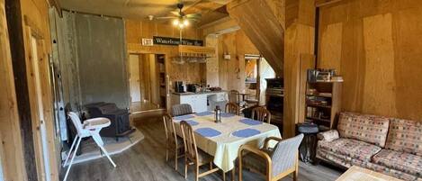 Un interior de cabaña acogedor, con comedor, sofá y kitchenette.