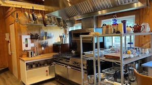 A kitchen with stainless steel appliances, wooden cabinets, and a window providing natural light.