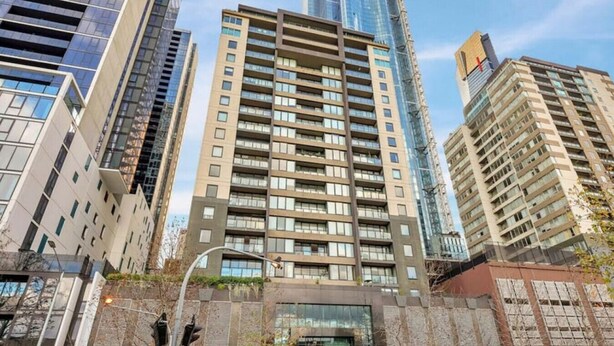 A high-rise residential building with multiple balconies, a modern architectural design, and a clear sky. - Central 2BR Apt in Southbank (Southbank)