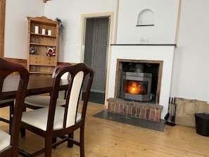 Cozy space with a traditional fireplace, wooden furniture, and a bookshelf.