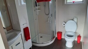 A compact bathroom with a shower enclosure, a toilet, and a sink. - Executive hideaway<br> (Christchurch)