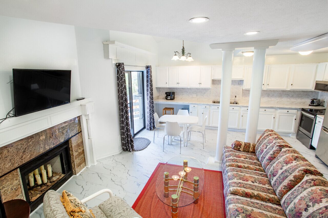 A modern living room with a fireplace, a sofa, and a television.