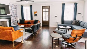 A modern living room with a fireplace, two sofas, a coffee table, and a TV. - All Shook Up at Pettigrew Adventures (Memphis)