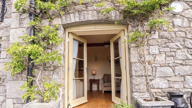 A stone building with a wooden door and a small porch area.