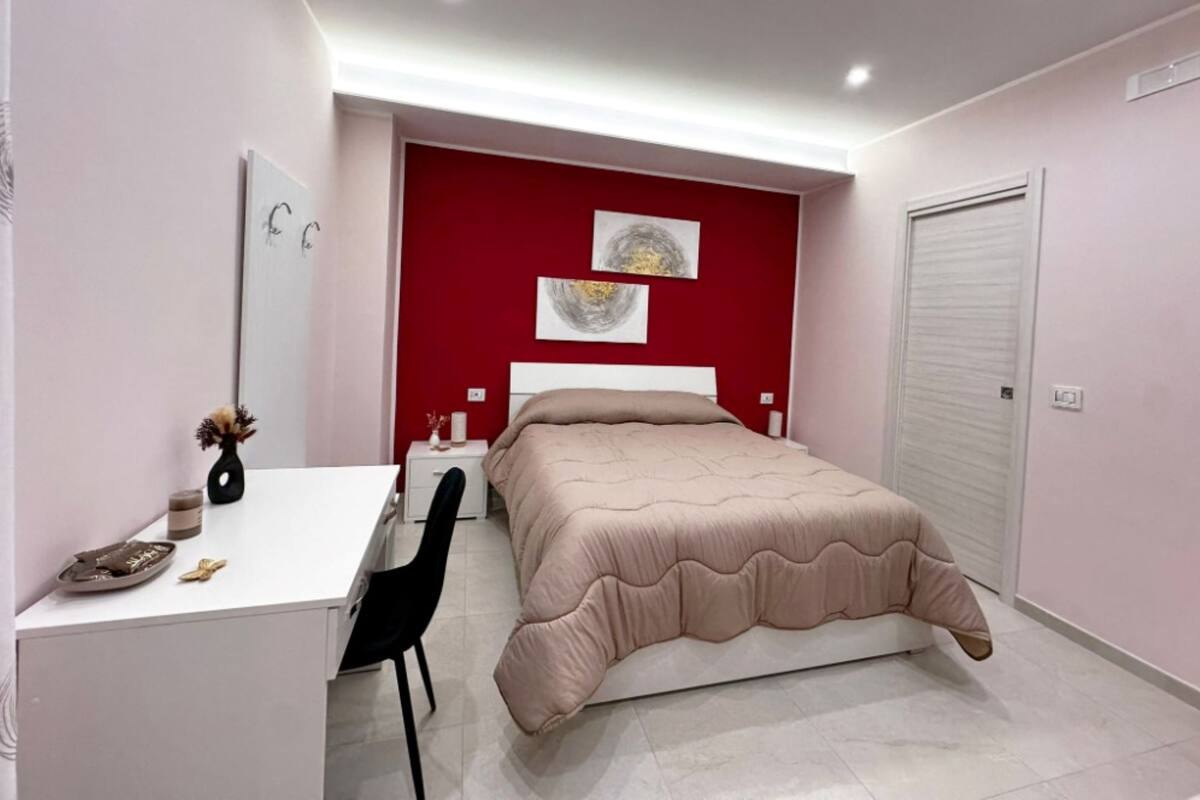 Une chambre à coucher avec un lit, un bureau, une chaise et une armoire.