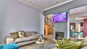 A modern living room with a sofa, a coffee table, and a TV mounted on the wall.