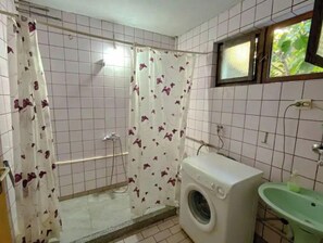 Een douche, handdoeken, zeep, toiletpapier