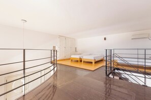 Une chambre à coucher moderne avec un lit, une armoire et un escalier.