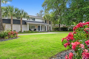 A two-story house with a covered porch, a well-maintained lawn, and a driveway leading to the entrance.