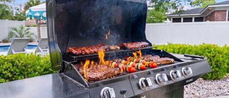 A Char-Broil grill with multiple cooking zones, a pool, and a white fence in the background.