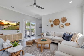 A modern living room with a sofa, coffee table, and a TV mounted on the wall.