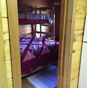 Cozy room with a bunk bed, featuring a comfortable bed covered in a patterned blanket.