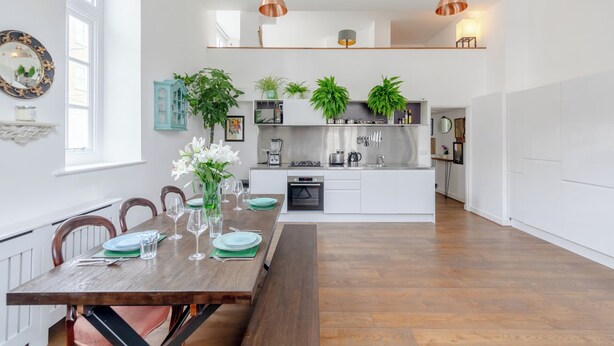 A modern kitchen with white cabinets, a built-in oven, and a coffee machine. - Luxurious & Chic 2BD Warehouse Flat - Old Street! (London)