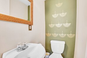 A bathroom with a white sink, a mirror with a wooden frame, and a toilet. - 17463 County Rd 18 (South Stormont)
