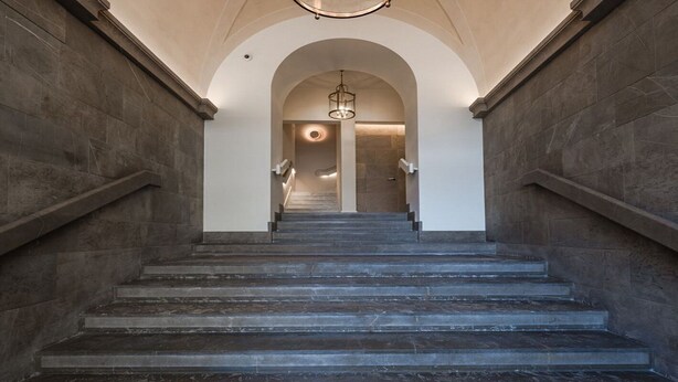 Eine prächtige Steintreppe mit einer modernen Leuchte oben.