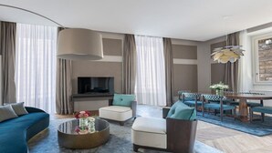 Ein modernes Wohnzimmer mit einer Couch, einem Sessel und einem Esstisch mit Stühlen.