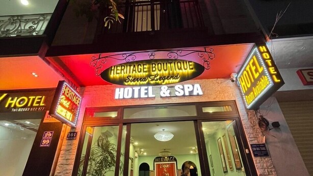 L’entrée d’un hôtel, avec une enseigne indiquant « Heritage Boutique Hotel & Spa » et un espace de réception bien visible, doté de sièges.