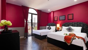 Une chambre d’hôtel avec deux lits, une grande fenêtre donnant sur un beau paysage et un mur rouge.