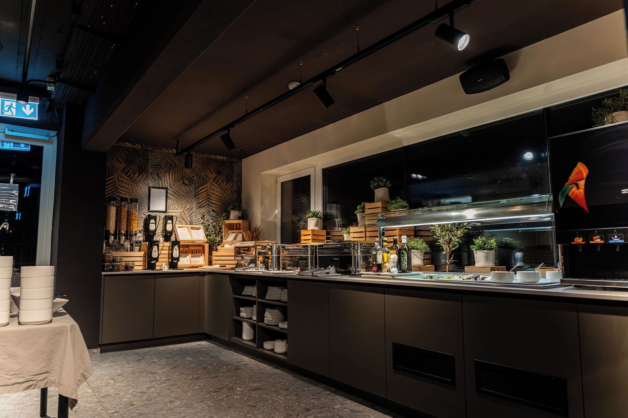 Una cocina moderna con una encimera larga, electrodomésticos integrados y varios armarios de almacenamiento.
