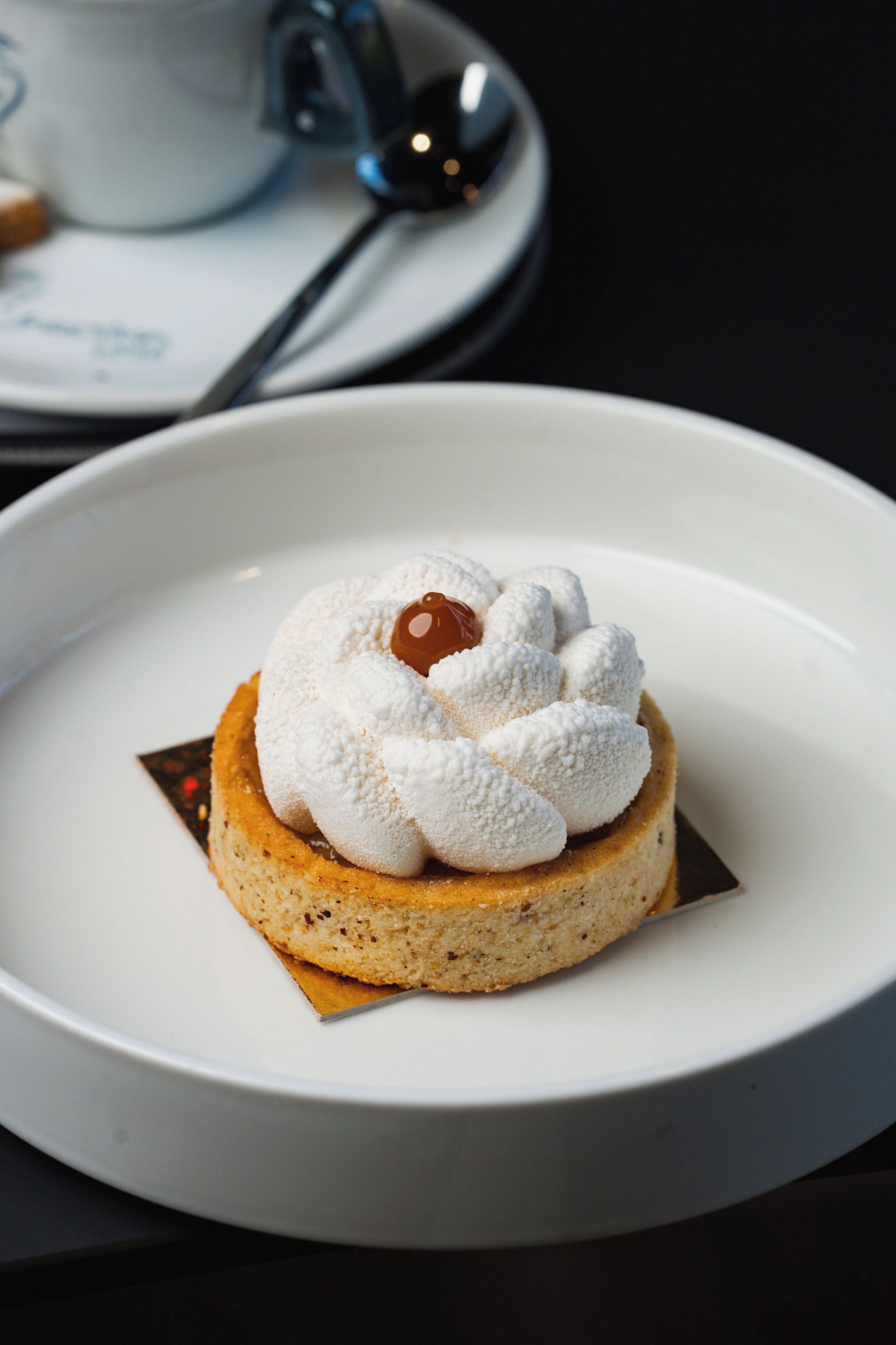 A dessert on a white plate with a chocolate piece on top.